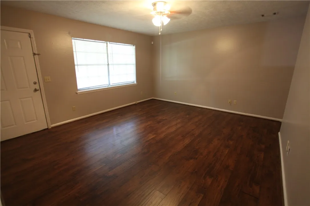 This inviting room features rich wood flooring and abundant natural light.