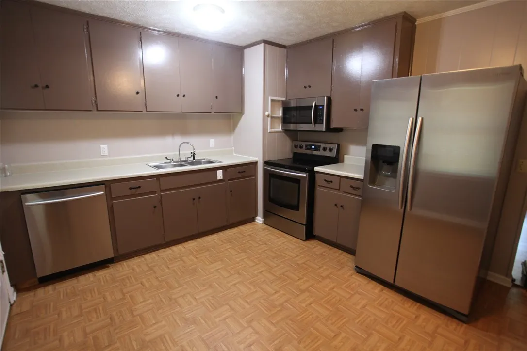This spacious kitchen offers ample cabinet storage, modern appliances, and durable flooring for everyday living.