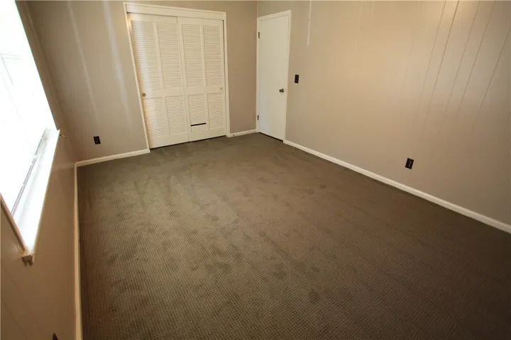 This spacious bedroom offers ample natural light and a neutral palette, awaiting your personal touch.