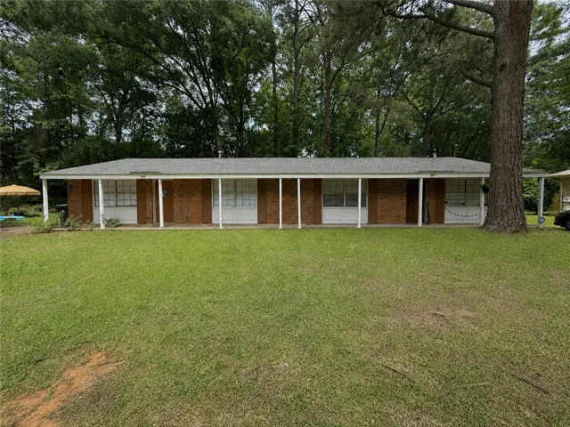 This brick residence offers a welcoming front porch set amidst a verdant lawn.