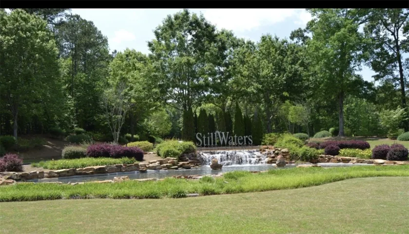 Lush landscaping and flowing water features greet you in this verdant outdoor setting.