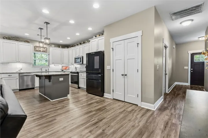 This inviting kitchen showcases modern appliances and durable flooring, seamlessly connecting to an open entryway.