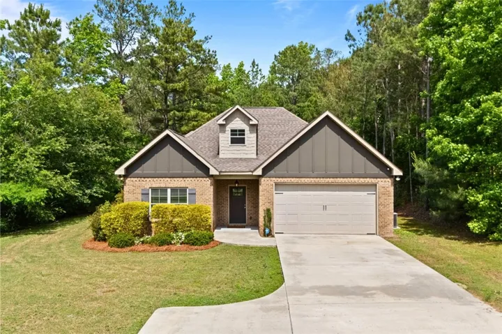 This charming home offers a convenient garage and lush greenery, creating a peaceful retreat.