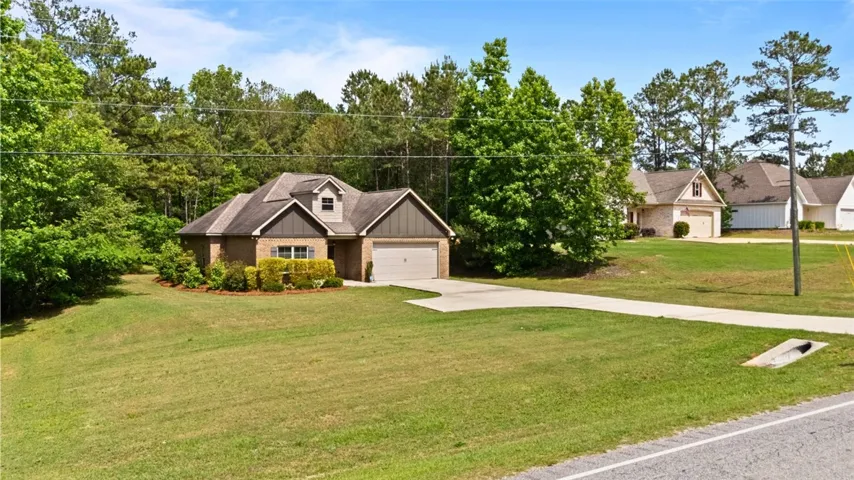 This charming home features a well-manicured lawn and a convenient attached garage.