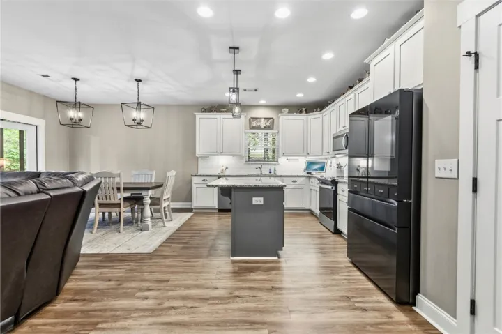 This kitchen features a central island, recessed lighting, and modern appliances.