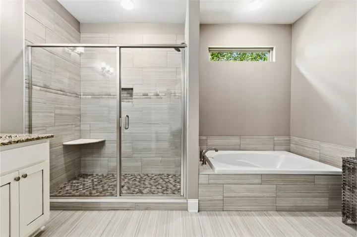 This serene primary bathroom offers a spacious walk-in shower and a luxurious soaking tub for ultimate relaxation.