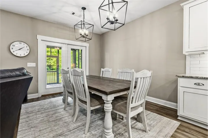 This dining area features elegant lighting and direct outdoor access, creating a bright and inviting space.