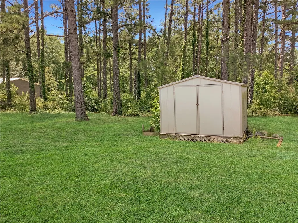A private backyard oasis with ample storage and towering mature trees.