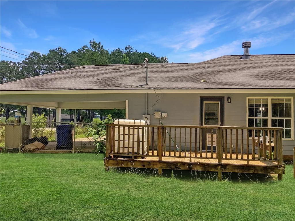 A spacious wooden deck provides ample outdoor living space, complementing the verdant yard.