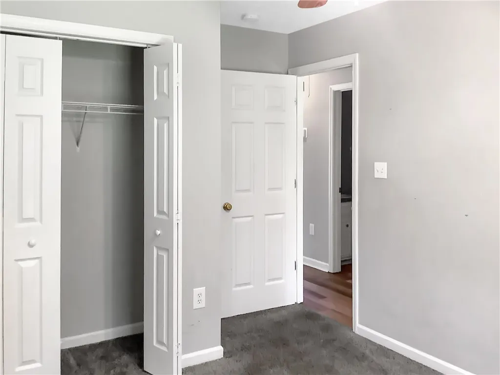 A well-maintained closet and doorway offer functional living spaces in this cozy room.