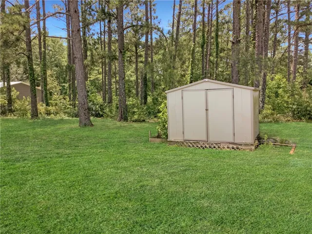 A private backyard oasis with ample storage and towering mature trees.