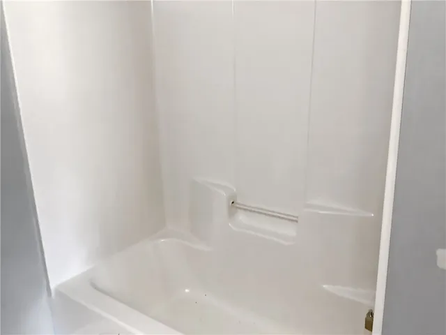 A pristine white tub and shower surround offers a clean, inviting space for daily refreshment.