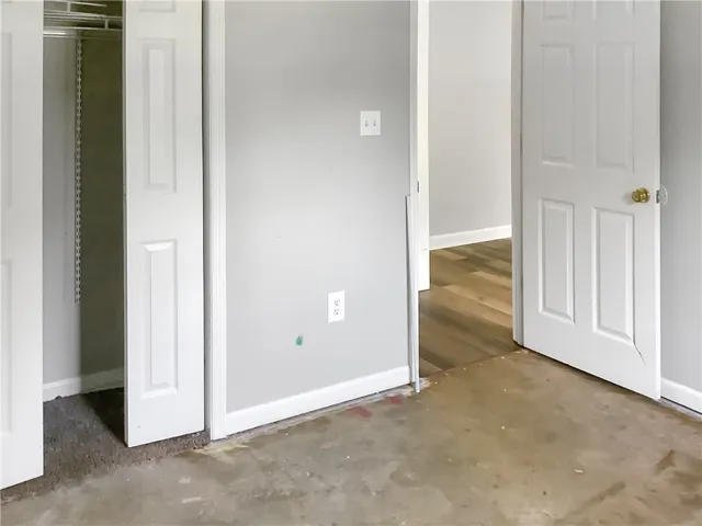 A versatile space awaiting your personal touch, featuring a functional closet and connecting doorway to adjacent areas.