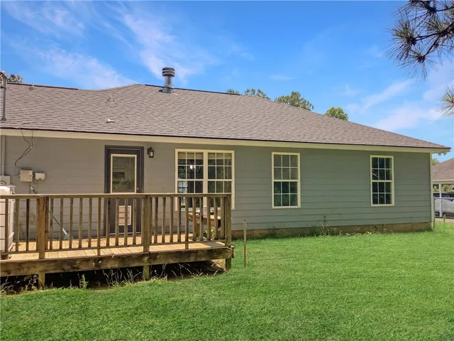 A wooden deck extends from the back of this residence, offering a serene outdoor retreat.