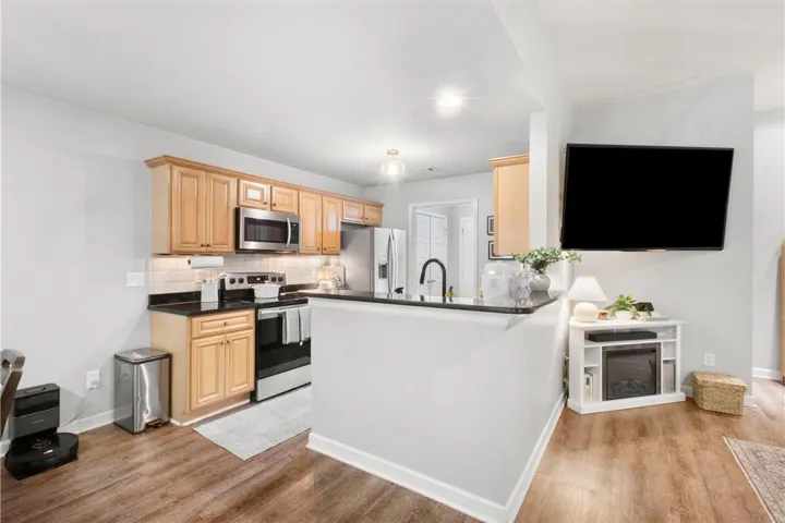 This kitchen features rich wood cabinetry, modern appliances, and a convenient breakfast bar.