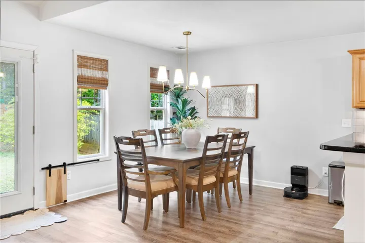 This bright dining area features ample natural light and a charming chandelier, perfect for entertaining.