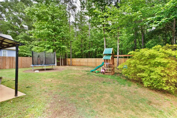 This expansive, verdant yard offers ample space for outdoor activities and relaxation.