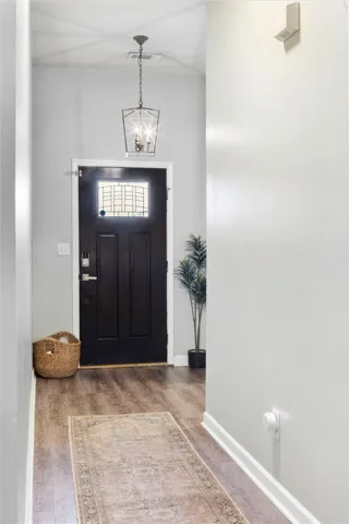Step into this welcoming entryway featuring durable flooring and an elegant hanging fixture.