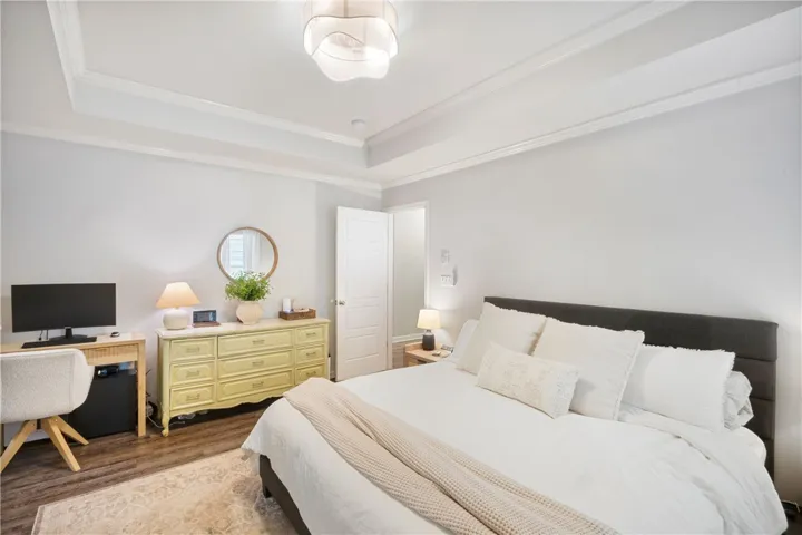This serene bedroom offers a comfortable retreat with tasteful architectural details and warm flooring.