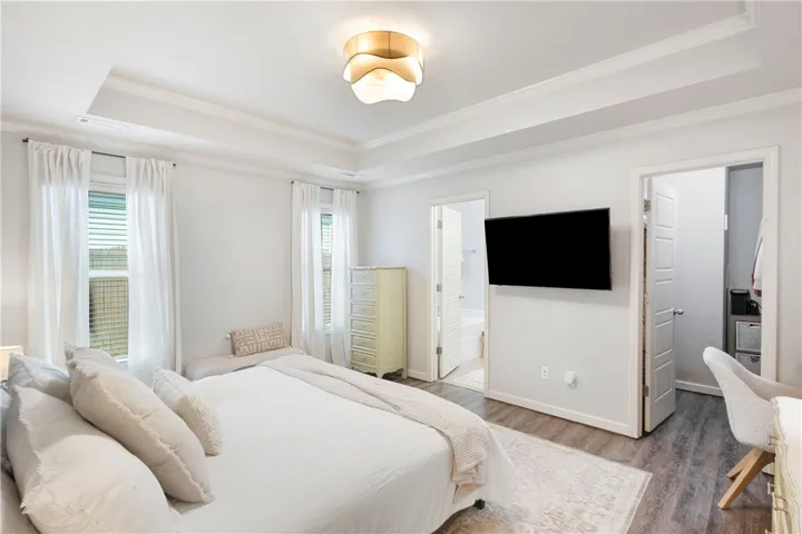 This tranquil bedroom features a spacious layout and elegant crown molding, creating a relaxing retreat.