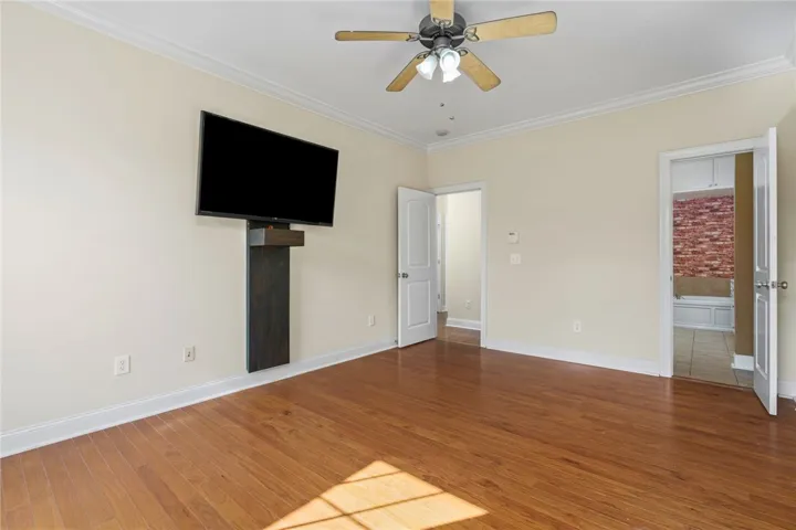 Hardwood floors and a ceiling fan create a pleasant atmosphere in this inviting room.