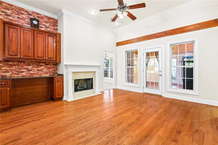 A welcoming living space features a cozy fireplace, warm hardwood floors, and access to the outdoors.