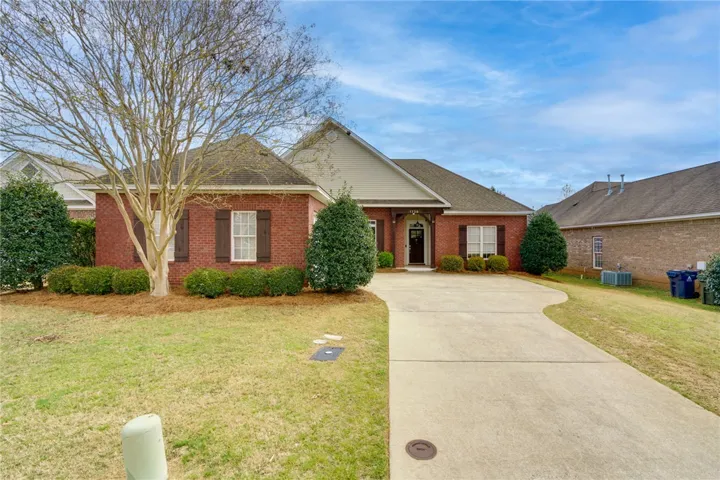 A classic brick exterior with a well-maintained lawn and a welcoming driveway.