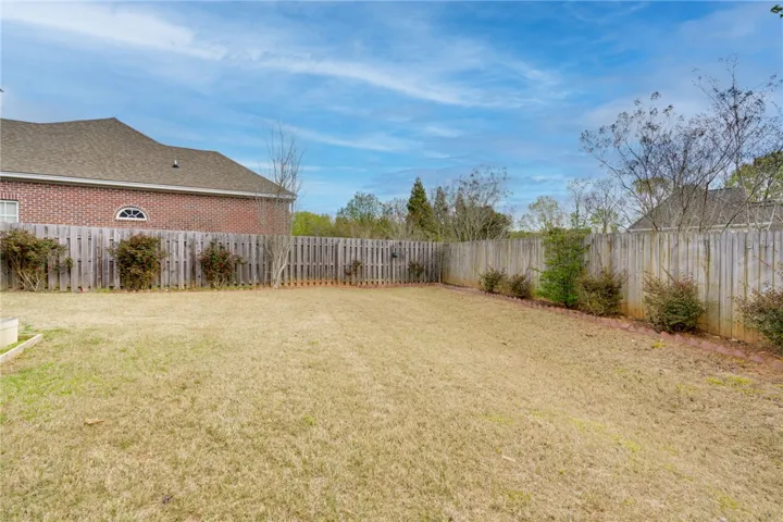 A well-maintained wooden fence encloses a private yard, offering a quiet outdoor retreat.