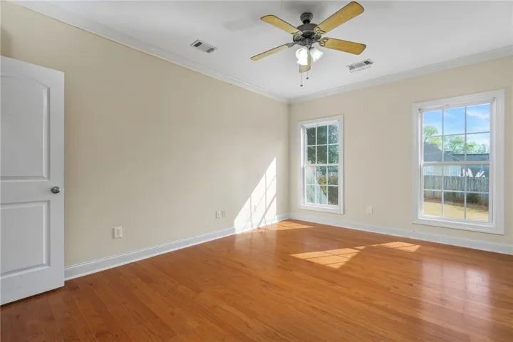 Hardwood floors and generous windows create an inviting, naturally illuminated space.