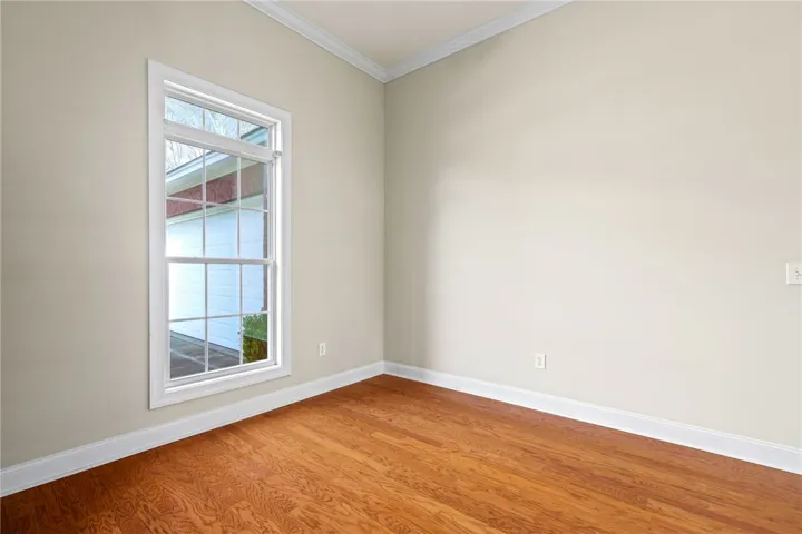 Well-lit room boasts warm hardwood flooring and crisp white trim.