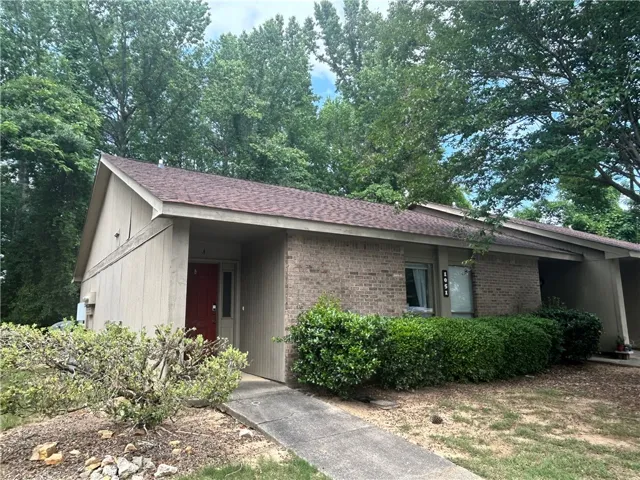This charming residence features a classic brick and siding exterior, nestled amidst mature trees.