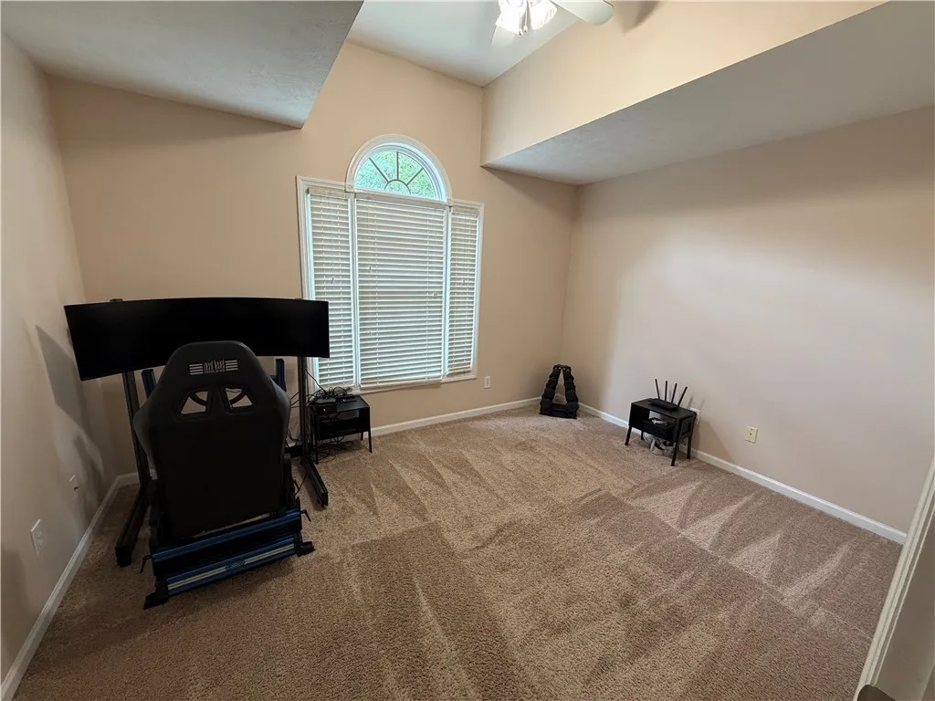 This spacious room features vaulted ceilings and ample natural light, ideal for a flexible living space.
