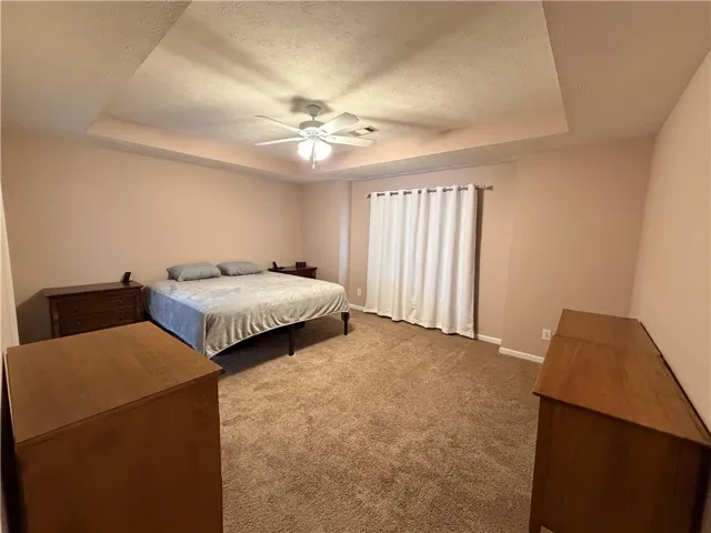 This spacious bedroom offers a tranquil retreat with plush carpeting and ample natural light.