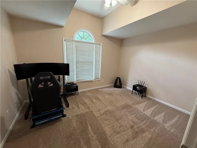 This spacious room features vaulted ceilings and ample natural light, ideal for a flexible living space.