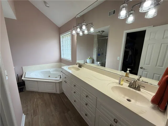 This primary bathroom features a double vanity and a built-in tub.