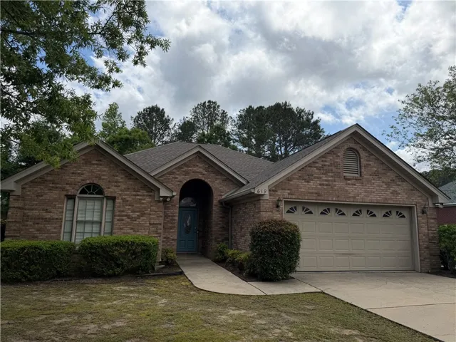 This classic brick residence features an attached garage and a welcoming front entrance.