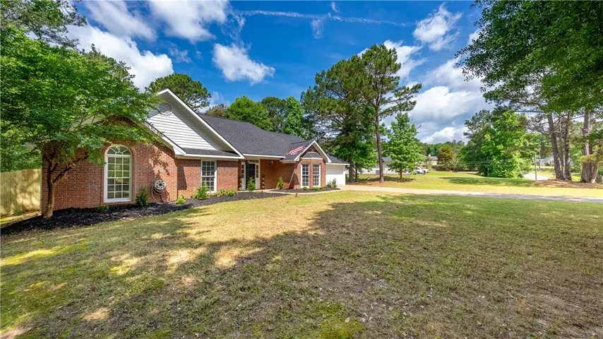 This charming brick home is nestled on a spacious lot with mature trees and a well-maintained lawn.