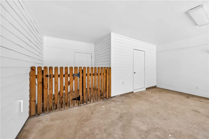 This versatile indoor space offers ample room and a convenient wooden fence, ideal for various uses.