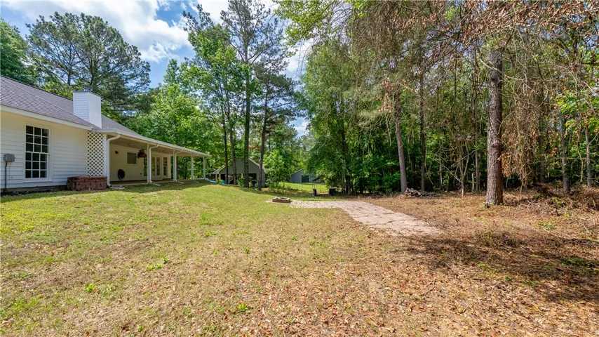 This serene property offers a spacious yard with a charming porch, perfect for outdoor living.