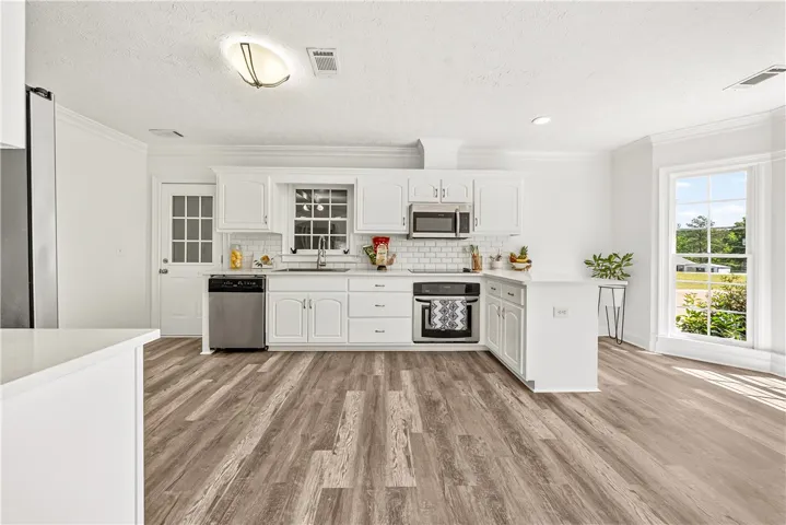 This bright kitchen features modern appliances, ample counter space, and durable flooring.