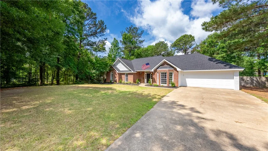 This classic brick residence features a spacious front yard and an attached garage.