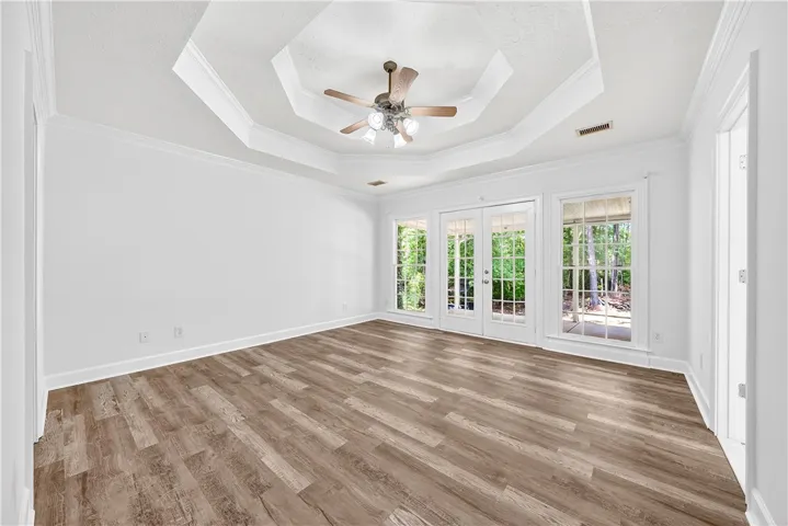 This bright room features a beautiful tray ceiling and durable flooring, with outdoor access.