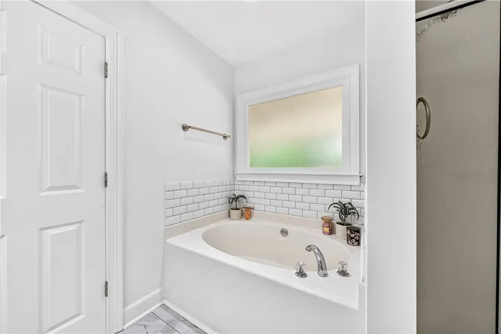 This bright bathroom features a spacious soaking tub, perfect for unwinding after a long day.