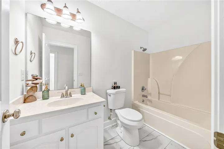 This bright bathroom features a spacious vanity and a combination tub and shower.