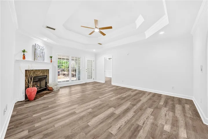 This living room features a fireplace and elegant tray ceilings, perfect for comfortable gatherings.