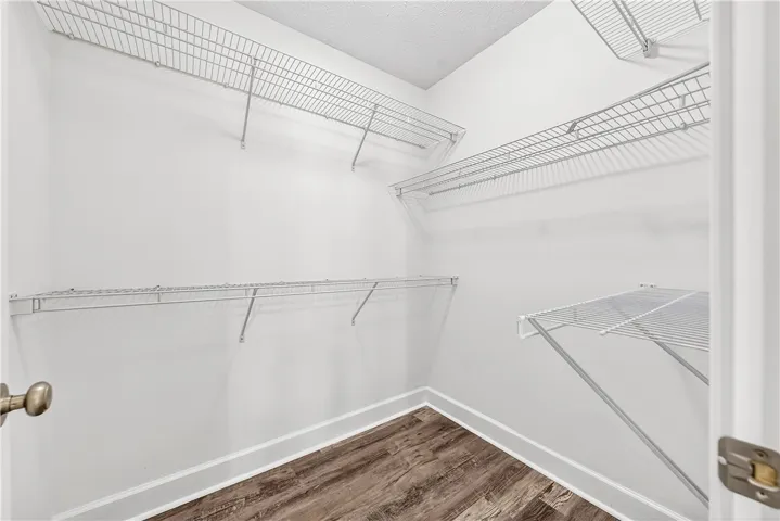 This spacious walk-in closet features ample wire shelving and attractive wood flooring.