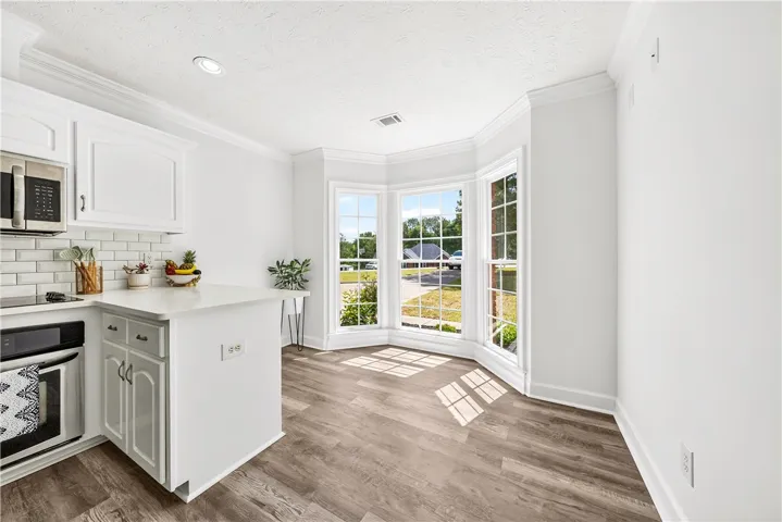 This bright eat-in kitchen features a bay window, modern appliances, and ample counter space.