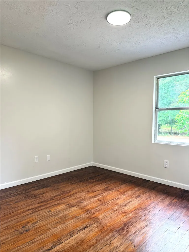 This airy room features durable wood flooring and a refreshing view of the outdoors.
