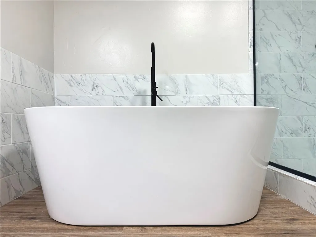 This primary bathroom features a freestanding soaking tub and elegant tile accents.