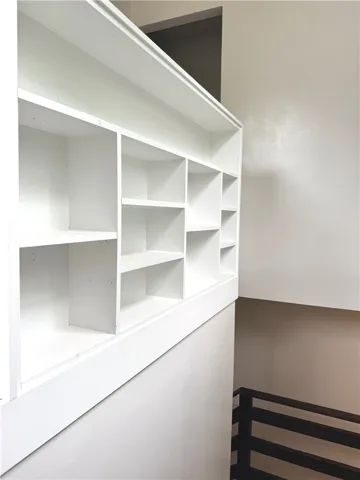 This interior features built-in shelving and a view of the stairs.